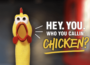 A picture of a rubber chicken that says "Who you callin' chicken?"