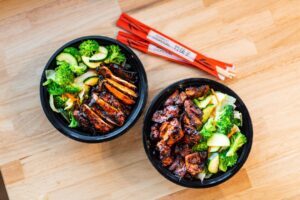 A picture of two spicy chicken teriyaki bowls with veggies